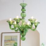 Vintage green glass chandelier with Murano style design, hanging in a room with art and arched wall, ideal for living room and dining room decor